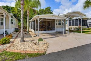 a house with a porch and a driveway at Pool + Dock Access! Boater’s Base in Lake Placid in Lake Placid