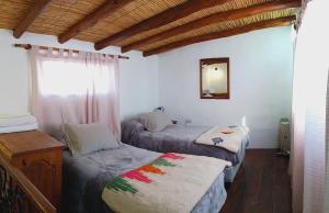a bedroom with two twin beds and a window at Cabaña Samka in Maimará