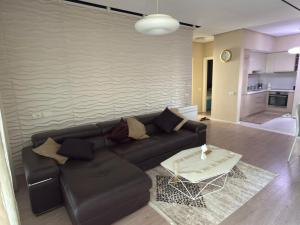 a living room with a black couch and a table at Lalzi Vacation Apartment in Lalzit Bay