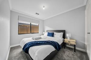 a white bedroom with a large bed and a window at Nest in The Vines in The Vines