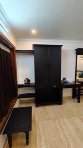 a living room with a black cabinet and a table at Blue Water Beach Resort in Varkala +80 photos