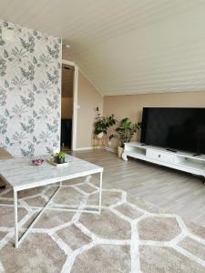 a living room with a large flat screen tv at Centralt och havsnära på Stensö in Kalmar +2 photos