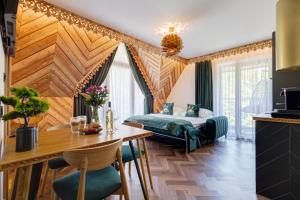 a hotel room with a bed and a table at Tatra Forest Apartments in Zakopane