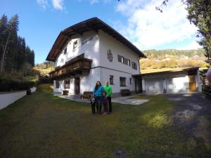 twee mensen die voor een huis staan bij Tiroler Hasenhöhle in Wenns