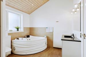 a bathroom with a tub and a toilet and a sink at Holiday Home Als - Starfish in Nordborg +20 photos