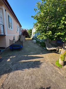 a yard with benches and a tree next to a house at Cozy-home in Kobuleti