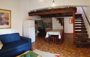a living room with a blue couch and a kitchen at Cabaña Samka in Maimará