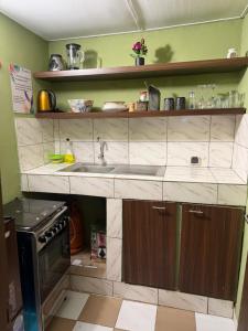 a kitchen with a sink and a stove at Studio Paisible Aéroport FHB in Abidjan