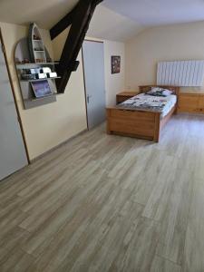 a bedroom with a bed and a wooden floor at Chez Peyrin in Labastide-Chalosse