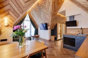 a kitchen and dining room with a wooden ceiling at Tatra Forest Apartments in Zakopane