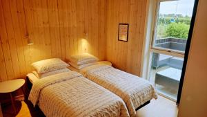 two beds in a room with a window at Holiday Home Als - Starfish in Nordborg