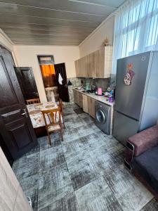 a kitchen with a stainless steel refrigerator and a table at Cozy-home in Kobuleti