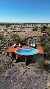 a swimming pool on a wooden deck in the desert at Boscia African Farm in Omomas
