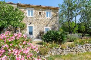a stone house with flowers in front of it at Chez Bacchus - Chambres in Gras