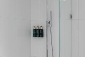 a glass shower door with two bottles on it at Clarion Hotel Gillet in Uppsala +46 photos
