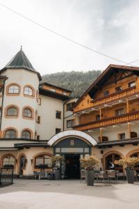 a large building with tables and chairs in a courtyard at Alpinresort Stubaierhof ****s in Fulpmes
