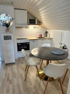 a kitchen with a table and chairs in a room at Centralt och havsnära på Stensö in Kalmar