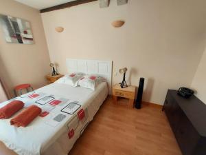a bedroom with a large white bed and a dresser at Le Liboureau in Saint-Jean-de-Vaux