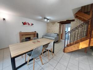 a living room with a wooden table and chairs at Le Liboureau in Saint-Jean-de-Vaux