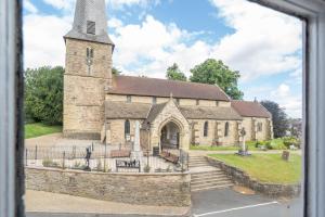 an old stone church with a tower with a steeple at Kings Arms Hotel in Cleobury Mortimer