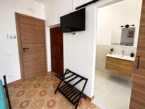 a room with a chair and a bathroom with a sink at O'Chianu in Lascari