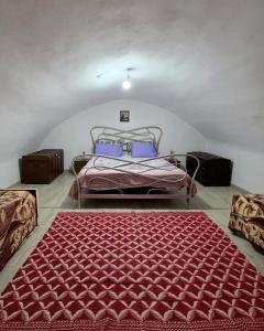 a bedroom with a bed with a red rug on the floor at Authentic Village House in Tourkolékas