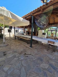 an outdoor patio with benches and an umbrella at Authentic Village House in Tourkolékas