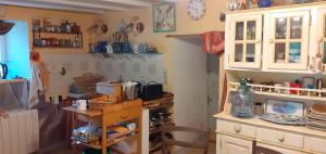 a kitchen with a counter and a table in it at Une chambre en Amazonie in Le Menoux