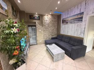 a living room with a black couch and flowers at Apartament bei Oberndorf in Oberndorf bei Schwanenstadt
