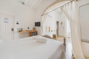 a white bedroom with a white bed and a doorway at Antico Mondo Rooms & Suites in Polignano a Mare