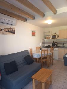 a living room with a blue couch and a table at La Garrigue in Calvisson