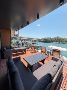 a deck with couches and tables and a view of the water at NiL Cottage in Ulcinj