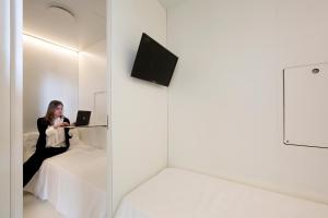 a woman sitting on a bed using a laptop at Bed & Boarding in Naples
