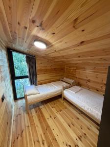 a room with two beds in a log cabin at NiL Cottage in Ulcinj