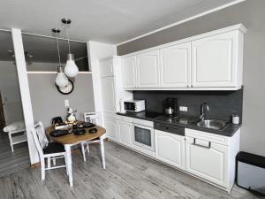 a kitchen with white cabinets and a wooden table at Ferienhof-Wohler-Wohnung-4 in Bojendorf +23 photos