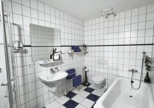 a bathroom with a sink and a toilet and a tub at Ferienhof-Wohler-Wohnung-4 in Bojendorf
