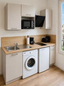 a kitchen with a washing machine and a sink at Studio cosy avec terrasse - Proche château in Fougères