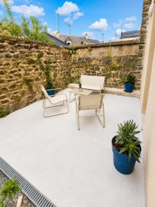 a patio with two chairs and a table at Studio cosy avec terrasse - Proche château in Fougères