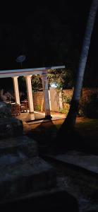 a white gazebo at night with a fence at Queens luma villa in Arugam Bay