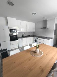 a kitchen with a wooden table and white cabinets at Casa La Cordelera in Salinas