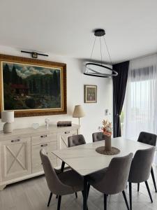 a dining room with a table and chairs and a painting at Stanisicguesthouse in Stanišiči