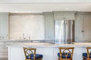 a kitchen with a counter with two chairs and a refrigerator at Two Bedroom Bayfront Condo with Water Views in Naples +8 photos