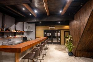 a kitchen with a long bar with stools at 尾道つばめ堂 Onomichi Tsubamedo in Onomichi