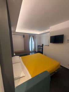 a bedroom with a bed with a yellow blanket at Alley House in Cefalù