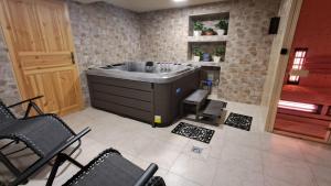 a bathroom with a tub and chairs in it at Dom Wczasowy U Góralki in Murzasichle +60 photos