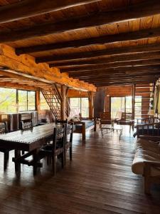 a large room with wooden floors and tables and chairs at Cabaña de campo in Tanti +4 photos
