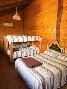 a bedroom with two beds in a wooden cabin at Cabaña de campo in Tanti