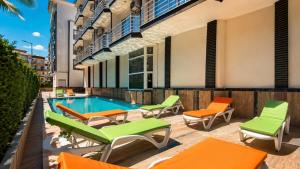 an apartment patio with chairs and a swimming pool at mood beach hotel in Didim