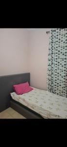 a bed with a pink pillow and a window at شقق للكراء في سلوان in Selouane
