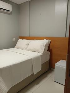 a bed with white sheets and pillows in a room at The Hotel in Teresina +5 photos